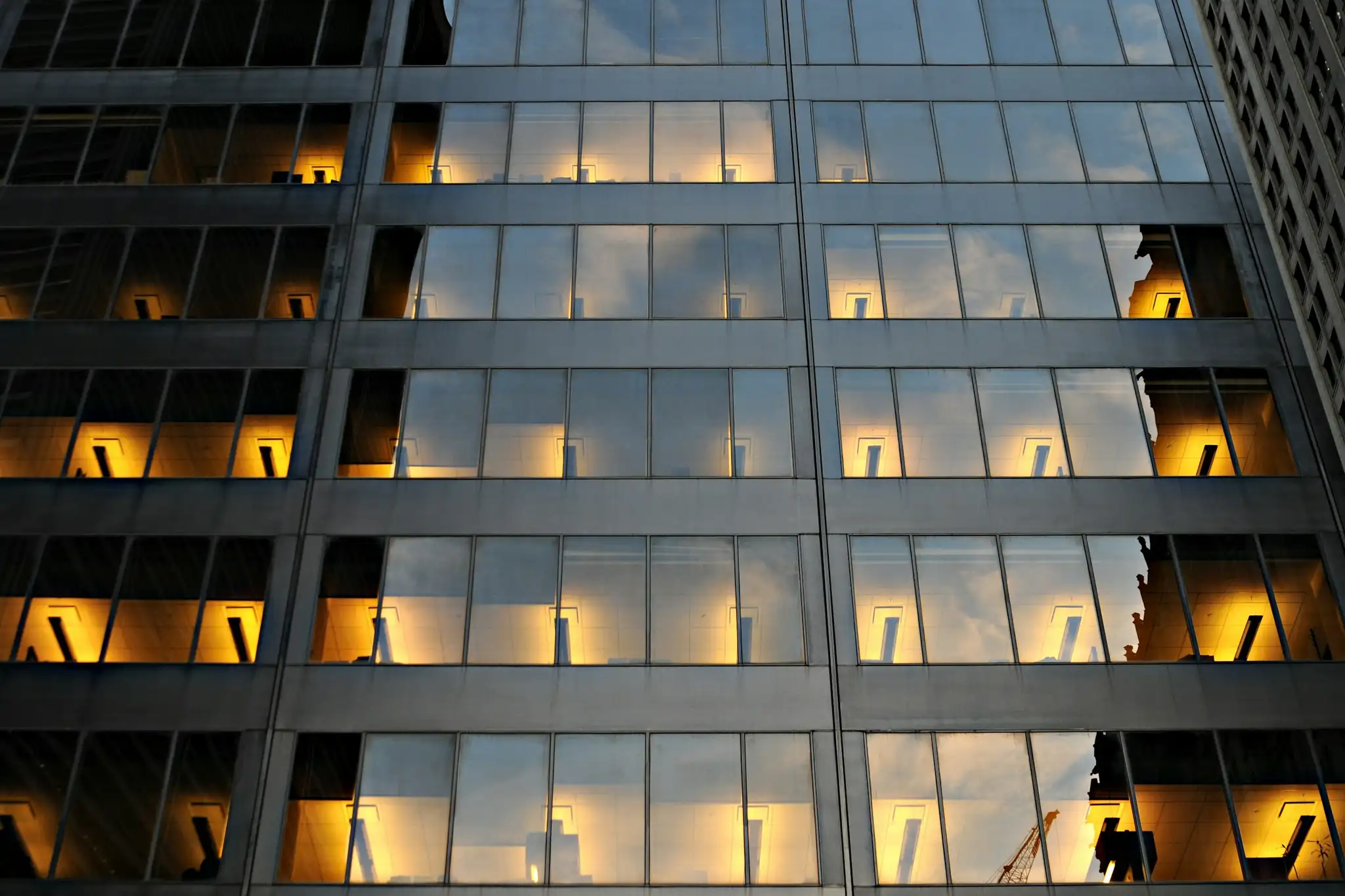 An office facade at night, a grid of lit windows