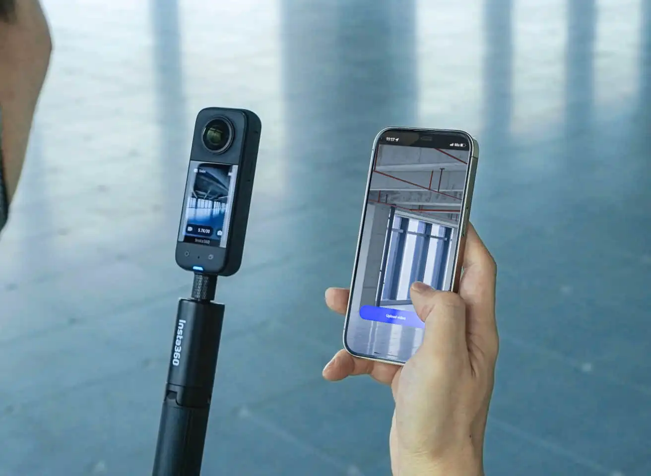 A 360° camera on a stick and a phone showing a captured interior