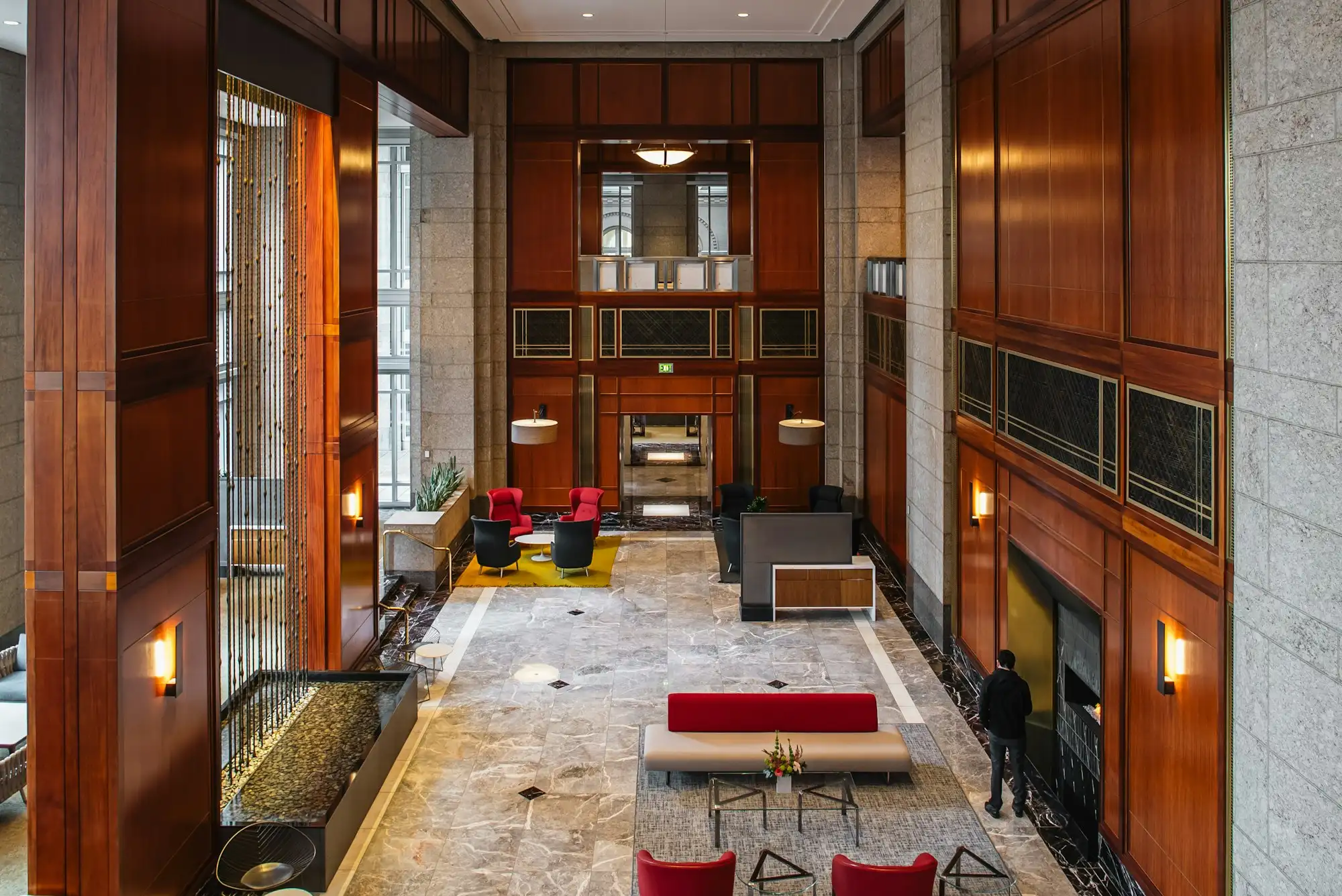 A tall office lobby with wood paneling and stone floors